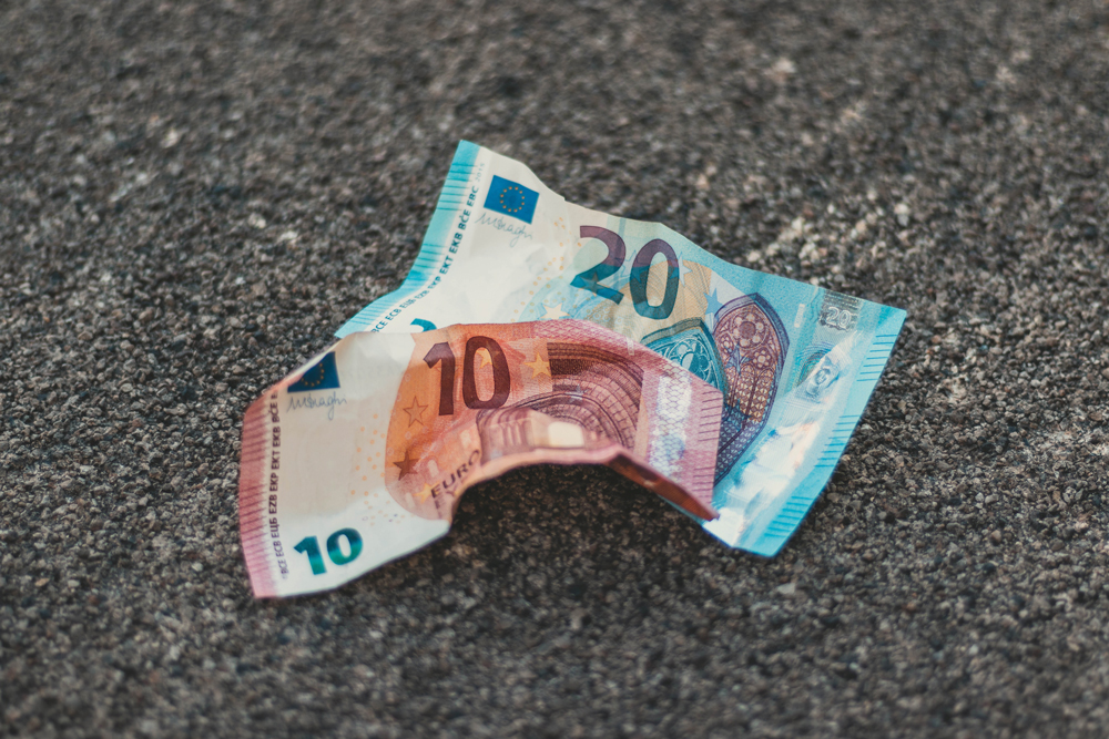 Zerknittertes Geld am Boden (Foto: Christian Wiediger auf Unsplash)