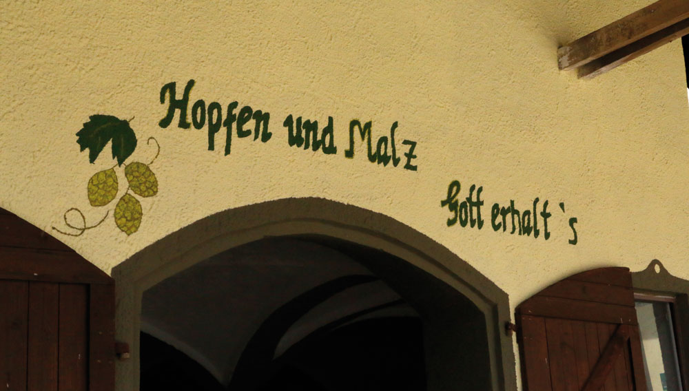 Blick auf einen Brauerei-Eingang mit Sinnspruch