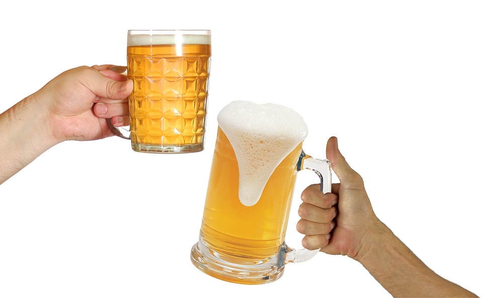 zwei Hände mit Bierkrügen prosten sich zu
