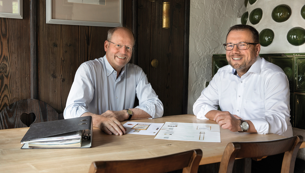 Die Geschäftsführer Carl Glauner und Markus Schlor sitzen an einem Tisch (Foto: Alpirsbacher)