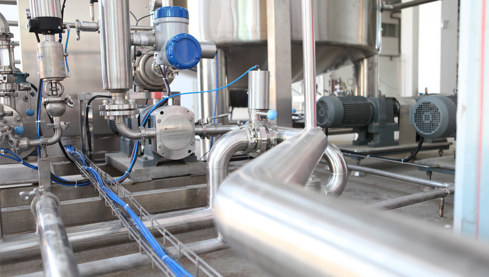 Rohrleitungen und Ventile unter Edelstahlbehälter (Foto: Crystal Kwok auf Unsplash)