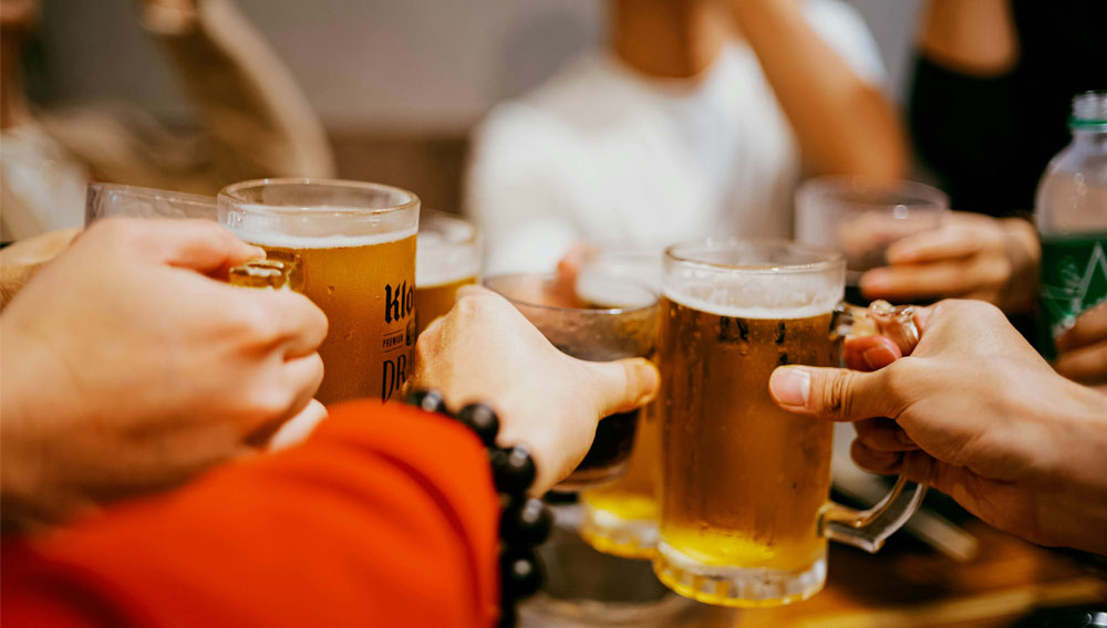 Personen stoßen mit Biergläsern an (Foto: tommao wang auf Unsplash)