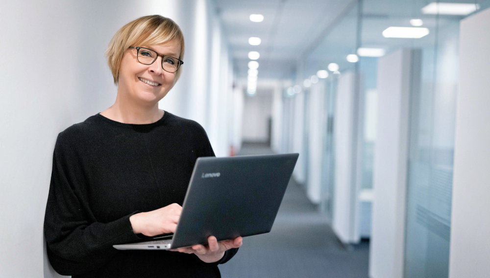 Porträtfoto von Nicole Pohl, die einen Laptop in den Händen hält