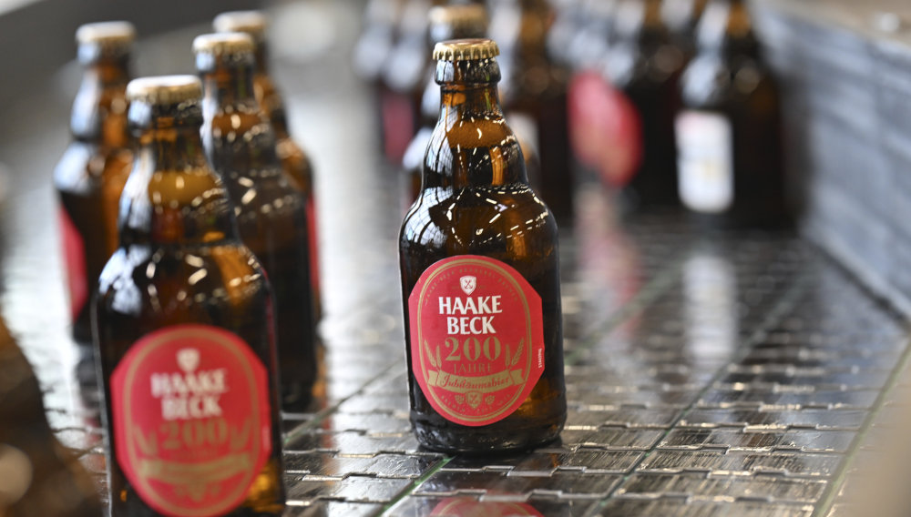 Bierflaschen der Jubiläumsedition von Haake-Beck auf einem Transportband
