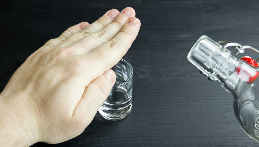 Hand, die ein Schnapsglas bedeckt (Foto: Bermix Studio auf Unsplash)
