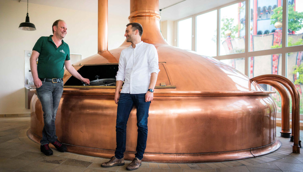 Braumeister Harald Ferstl und Bräu Jacob Horsch vor dem Braukessel (Foto: Brauerei zum Kuchlbauer)