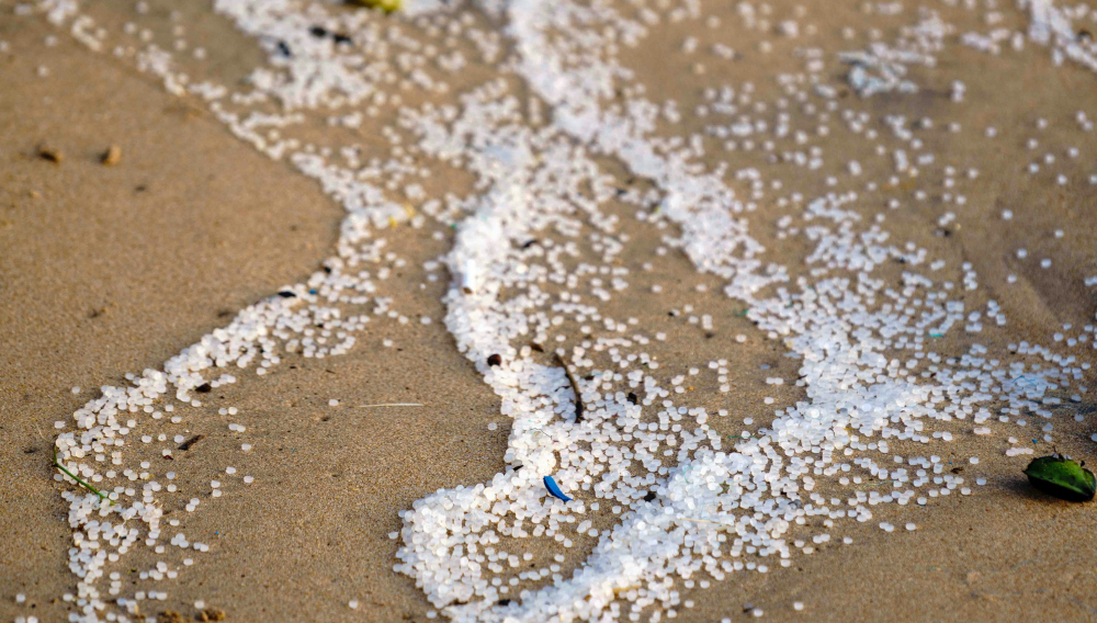 Plastikpartikel an einem Sandstrand (Foto: Soren Funk auf Unsplash)