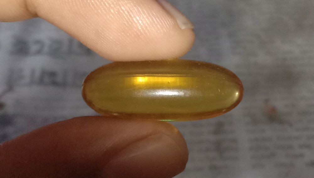 Zwei Finger halten eine Fischöl-Kapsel (Foto: Benutzer Billjones94 auf Wikimedia Commons, Public Domain)